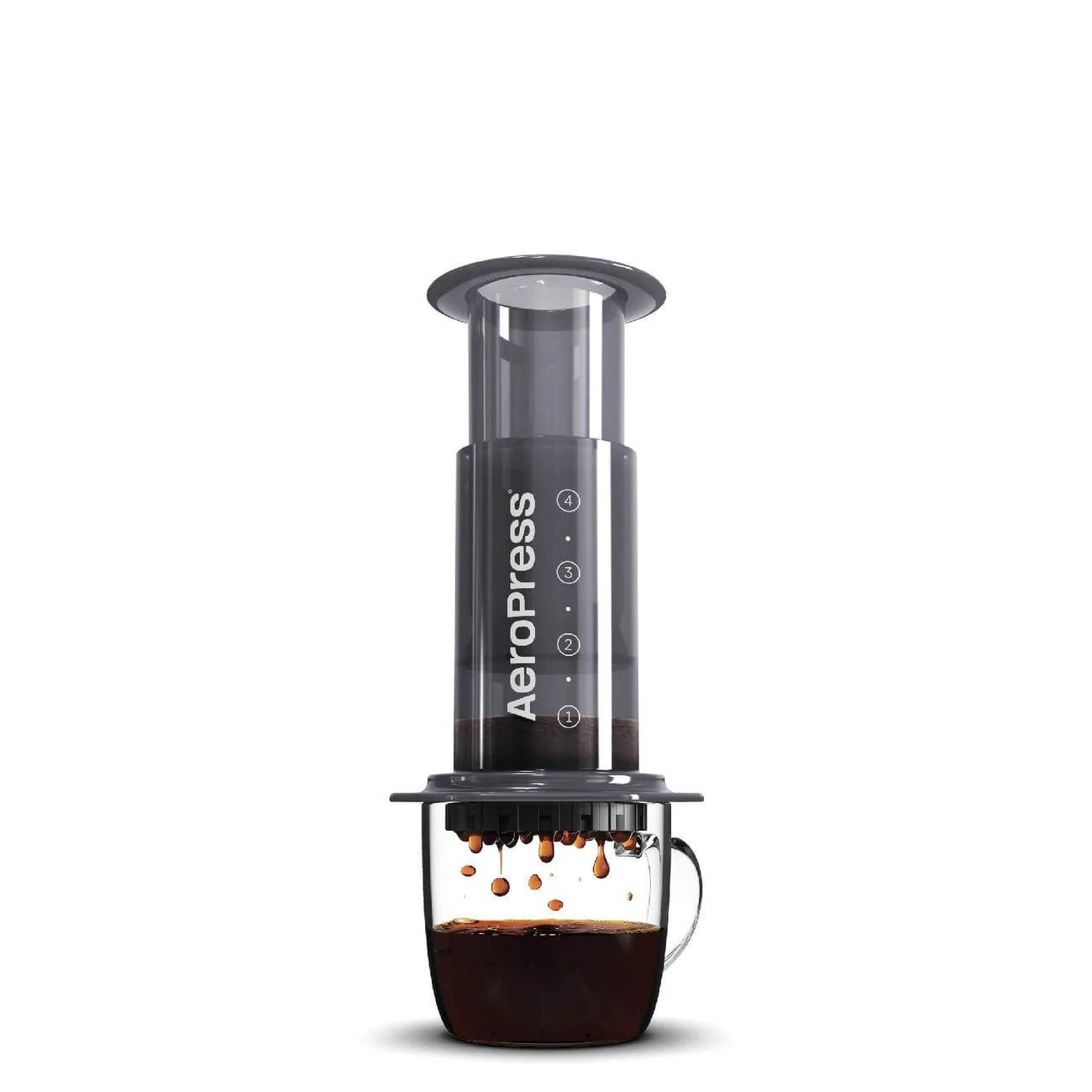 Billede af en AeroPress-kaffemaskine, der presser kaffe i en gennemsigtig glaskop. Den omvendte AeroPress er vist i aktion, hvor kaffe drypper fra bunden ned i koppen nedenfor.