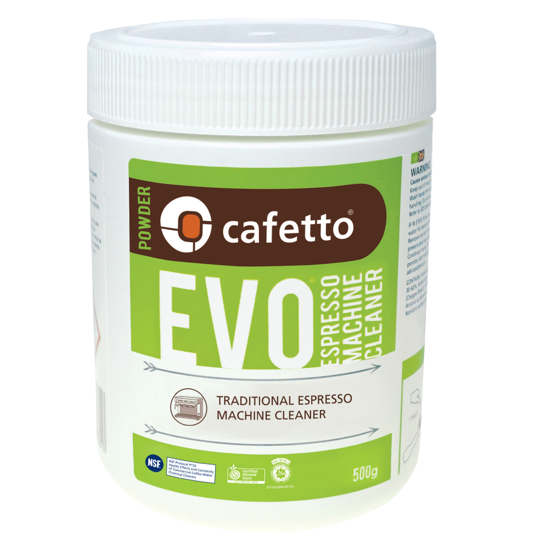 En hvid beholder med Cafetto EVO Espresso Machine Cleaner, 500g. Etiketten er grøn og hvid med tekst, der angiver, at den er til traditionelle espressomaskiner. Beholderen har et skruelåg og detaljerede brugsanvisninger på siden.