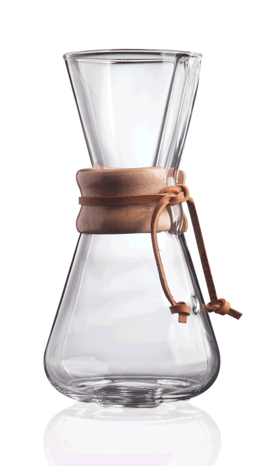 Chemex Classic Kaffebrygger 3-kopper (CM-1C) er en klar glaskaraffel med en trækrave og lædersnysning, der kan prale af en timeglasform til at mestre hældningsteknikker. Det er sat tomt på en hvid baggrund.