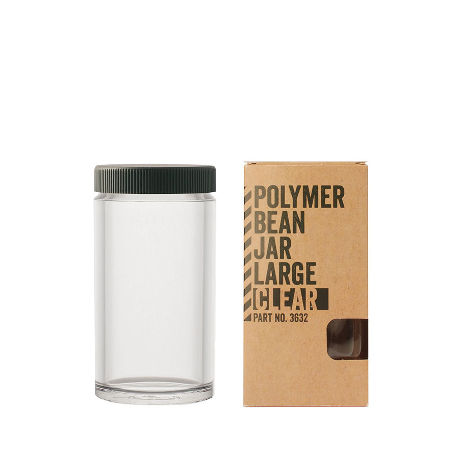 Comandante Polymer Bean Jar med låg, Klar stor er udstillet tom og gennemsigtig sammen med sin brune papemballage mærket "Polymer Bean Jar Large Clear, Part No. 3632", med et mørkegrønt låg og ideel til kaffeopbevaring for at bevare dine bønner.