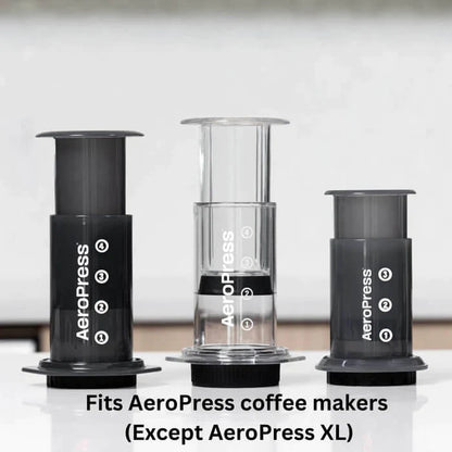 Tre AeroPress kaffemaskiner sidder på en hvid bordplade, fremhævet for deres smagsneutral filtrering. Alle modeller er kompatible med tilbehør, undtagen XL-modellen.