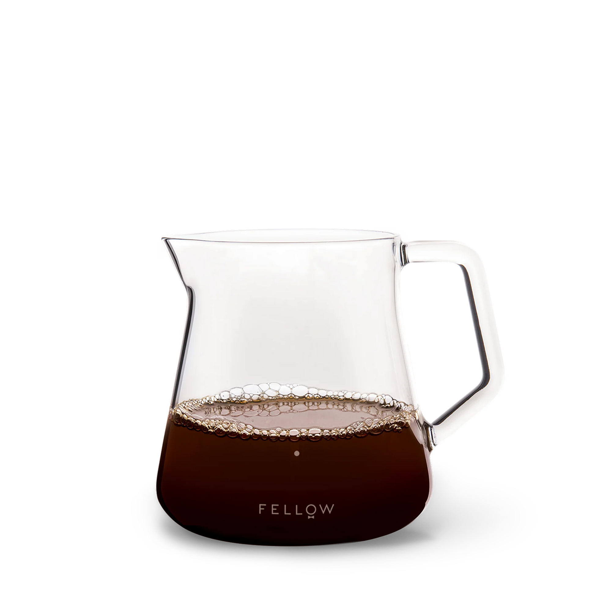 The Fellow Mighty Small Glas Karaffel, halvt fyldt med kaffe og bobler, passer perfekt sammen med Stagg [X] Drypperens for et ideelt kaffe-til-vand forhold. Den har en bred tud, robust håndtag og "Fellow" i hvid på en sort base.