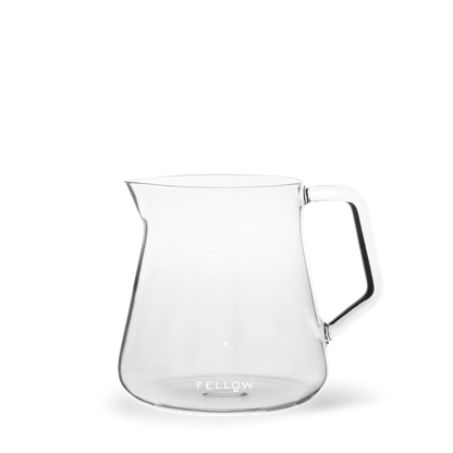 Fellow Mighty Small Glas Karaffel, en gennemsigtig glaskande med et slankt moderne design, er ideel til kaffeentusiaster. Med sin brede base og smalle tud komplementerer den Stagg [X] Drypperens pour over filterholderen. "Fellow" er elegant printet nær bunden.