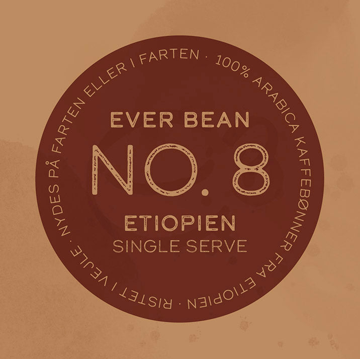 En brun cirkulær etiket centrerer teksten "EverBean Single Serve" og langs kanten står "100% Arabica kaffebønner fra Etiopien" plus "Nydes på farten eller i farten", hvilket markerer den som en specialkaffe, der er ideel til kaffeelskere på farten.